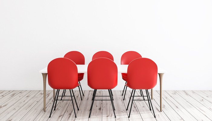 Six red chairs around a table.